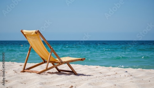 Empty Yellow Beach Chair on Sandy Shore Overlooking Calm Ocean Under Clear Blue Sky