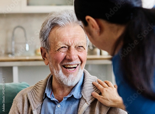 Doctor or nurse caregiver with senior man talking and having fun at home or nursing home