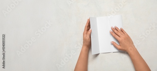 Hands holding blank brochur...
