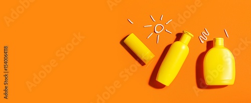Bottles of sunscreen cream on orange background with space for text