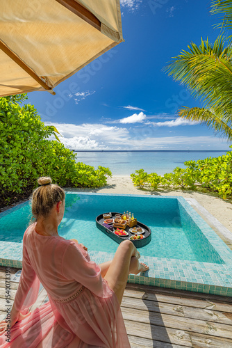 Stunning sexy woman enjoying floating breakfast in private villa infinity pool view. Luxury beach resort tropical vacation destination paradise. Carefree relaxation travel escape, tranquil tourism