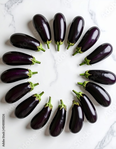Fresh eggplants arranged in a circular pattern on a light surface