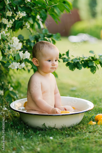 Baby Sitting In Outdoor Bath Tub With Fruit And Flowers