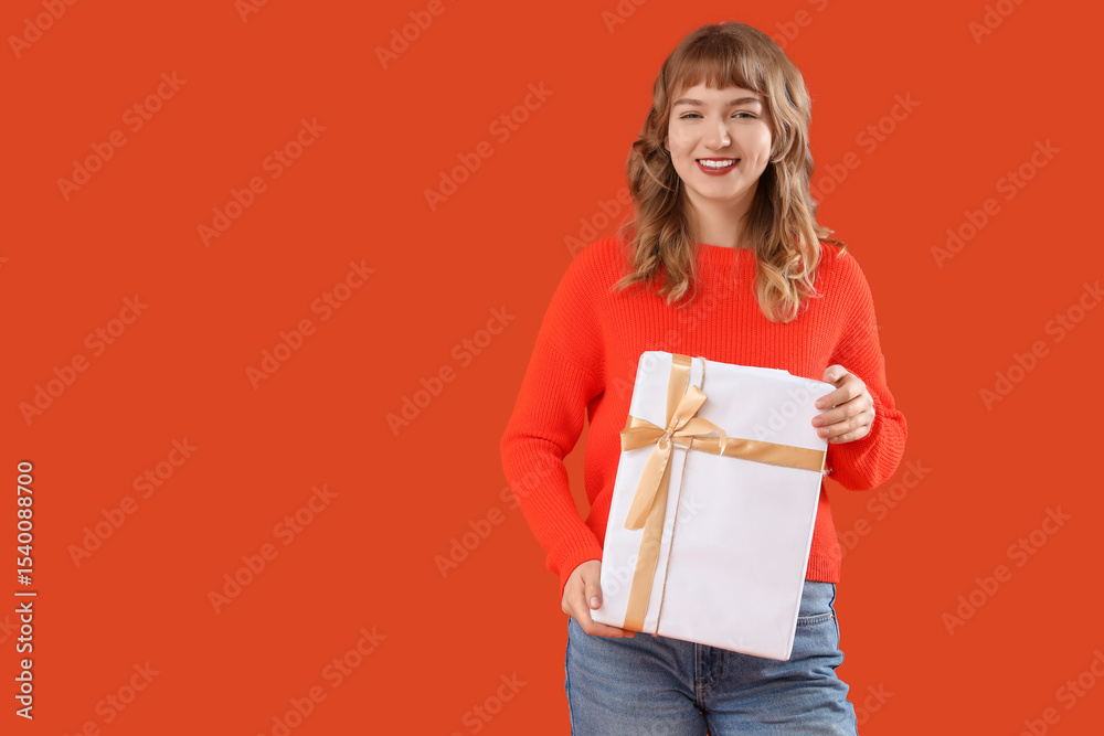 Beautiful young woman with gift box on orange background Beautiful young woman with gift box on orange background