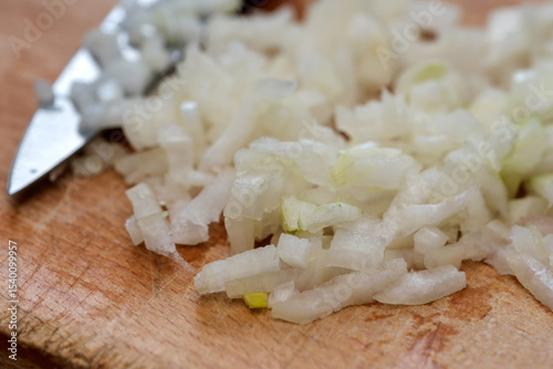 Chopping fresh onions on a wooden cutting board in a cozy kitchen