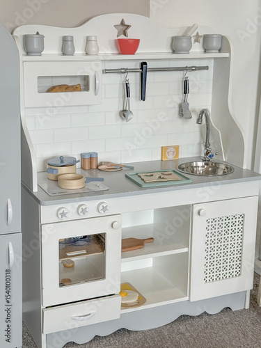 White wooden toy kitchen with accessories for kids