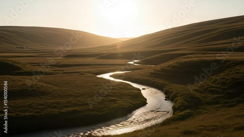 Golden Sunset Light Reflecting On Winding River Through Lush Green Valley Landscape