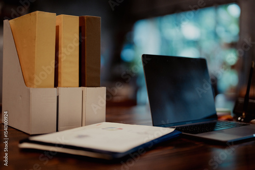 Desktop view with file holders, documents, and a laptop, representing structured office work and document management.