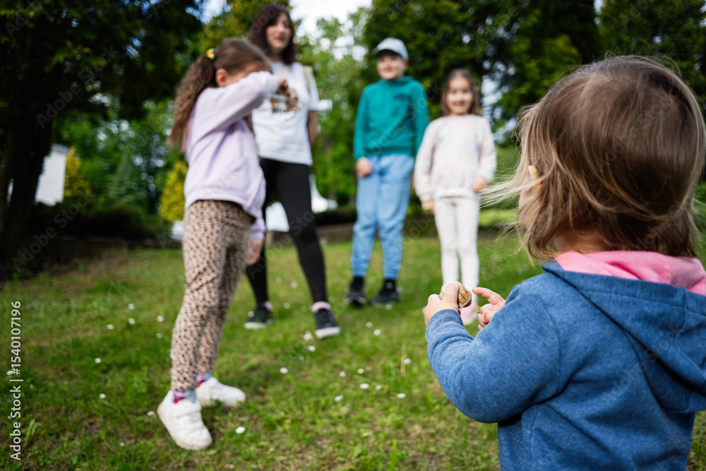 Obraz premium Children playing outdoors in a grassy park area during a sunny day