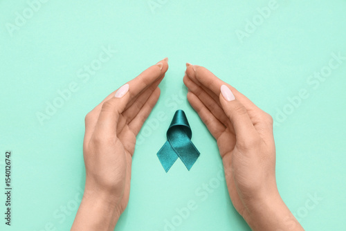 Female hands with teal ribb...