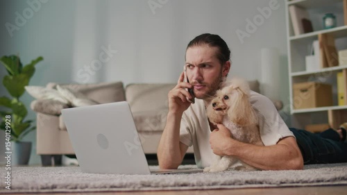 Work-Life Integration, Focused Routine. Vertical Video. Young Man Works on Laptop at Home With His Dog Nearby. Calm Scene of Emotional Stability, Comfort, and Everyday Pet-Inclusive Productivity