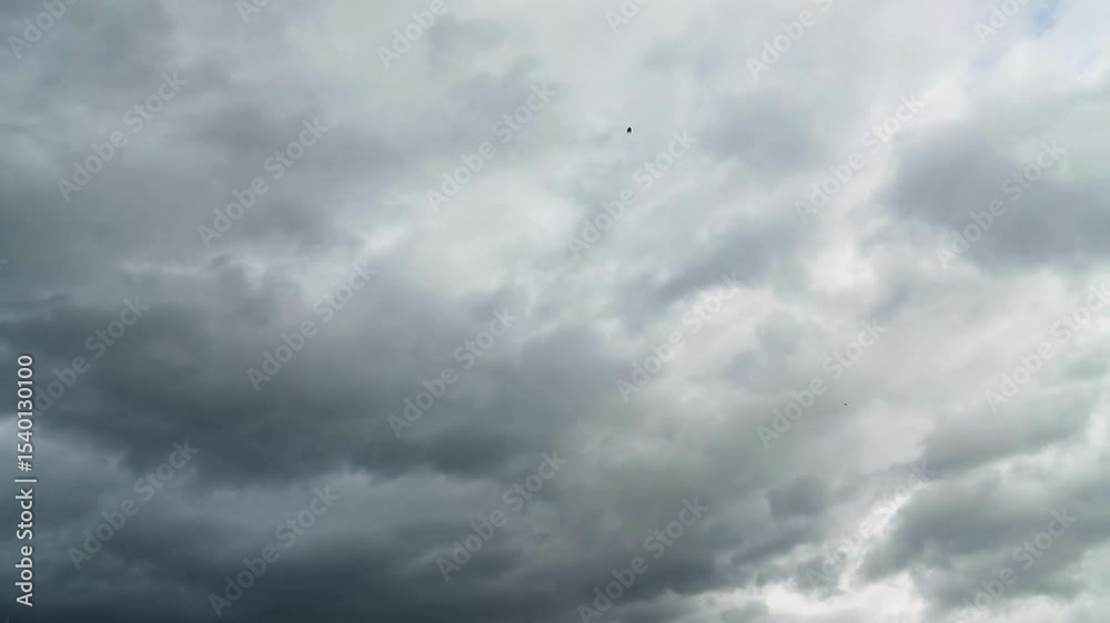 Timelapse of an overcast cloudscape with fast moving white clouds drift across an overcast sky, capturing the beauty of nature and changing weather patterns timelapse