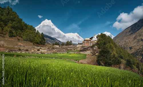 Scenic landscape with ancient temple against backdrop of Mount Manaslu, part ...