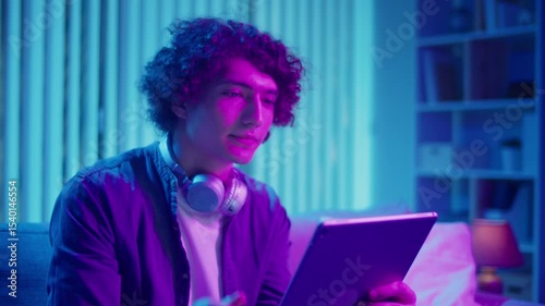 Digital Detox, Mental Health, Focus Mode. Man Relaxes on Sofa Using Tablet, Possibly Watching Streaming Content or Reading. Everyday Self-Care and Slow Living in the Digital Age