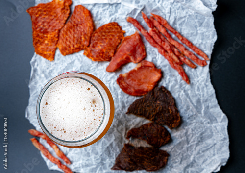 Meat snacks jerky and cabanos isolated assorted on parchment with beer top view