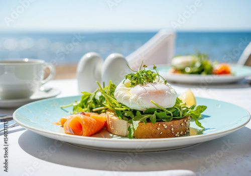 vibrant breakfast plate featuring poached egg, smoked salmon, and arugula on toasted bread against a seaside backdrop with sunlight reflecting off the ocean