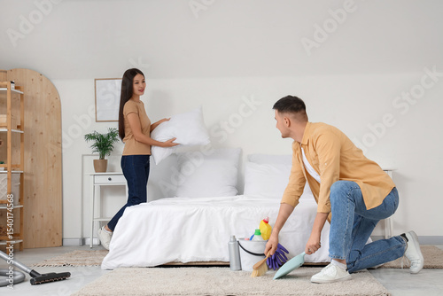 Cute young couple cleaning ...