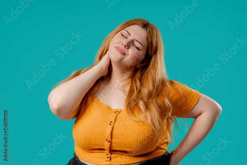 Tired plus size woman feeling pain in neck joint, massaging muscles,rubbing head