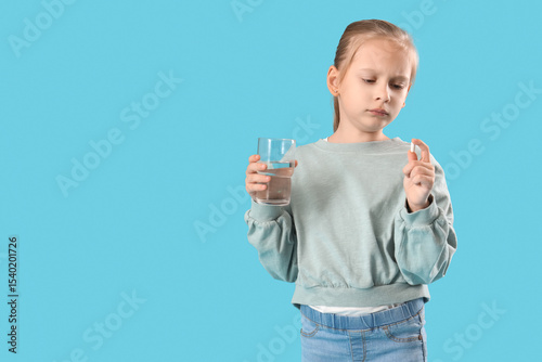 Little girl with pill and g...