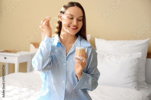 Young woman cleaning ears w...