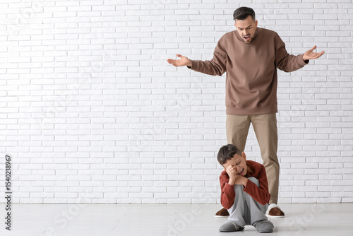Angry father shouting at hi...