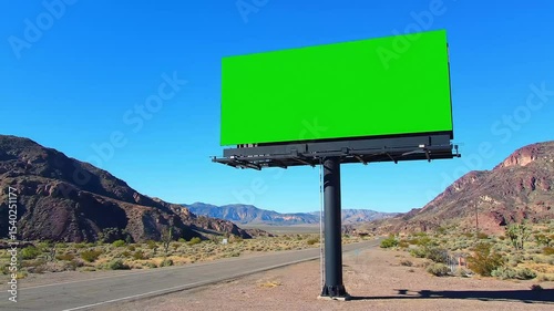 Green screen billboard in a desert landscape offers advertising space for content