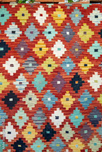 close-up of colorful diamond pattern on a brown kilim rug