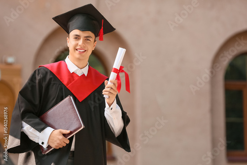 Happy male student with dip...