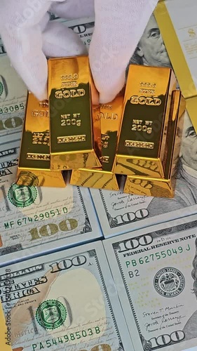 Discovering wealth with gold bars and cash on a table filled with hundred dollar bills