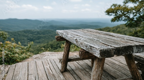 Rustic wooden picnic table overlooking a mountain vista.