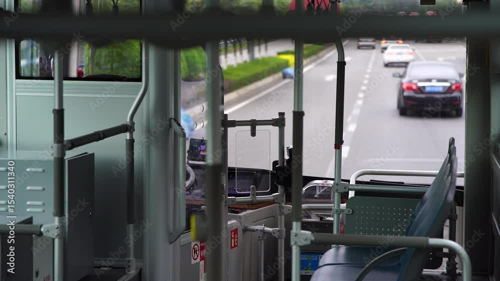 Interior perspective from city bus on a partly cloudy day with cars and pedestrian traffic on a paved road in Asia Interior perspective from city bus on a partly cloudy day with cars and pedestrian traffic on a paved road in Asia