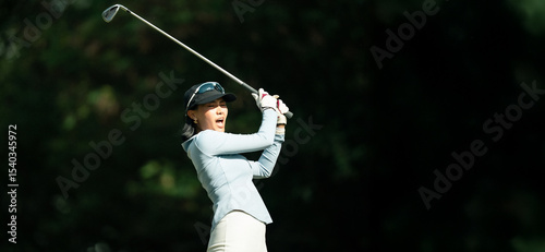 A woman is swinging a golf club
