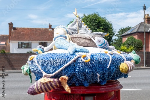 Langstone Harbour England - June 17 2025: summer scene knitted post box topper with fish mermaid and boat