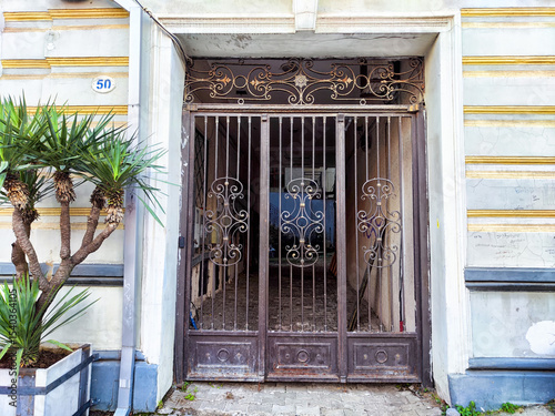 Elegant wrought iron gate leads to a historic building entrance in a quaint urban area