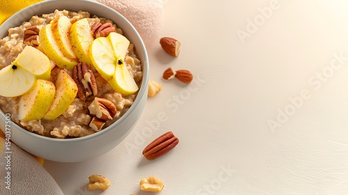 A close-up overhead shot reveals a delicious bowl of creamy cinnamon oatmeal topped with pecans and sliced s ready for a healthy and comforting breakfast.