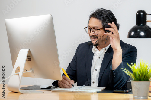 Confident young professional attending virtual meeting with headset in modern office setting