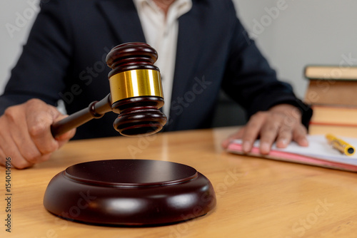 Close-up of judge’s hand hitting gavel, symbolizing legal decision, authority, and justice.