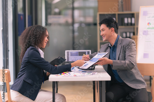 Two businessmen looking at computer screen with many graphs and charts and tablet for statistics, financial reports and planning revenue, profit or sales in office.