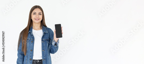 Close up portrait of a smiling woman showing blank screen mobile phone while standing isolated over white background