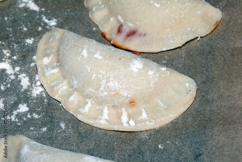 Close up of home made Chinese dim sum dumplings Jiaozi or Gyoza on bakking tray ready to be fried