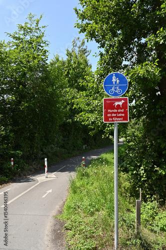 Selm, Germany, June 11,2025 Shared Pedestrian and Bicycle Path with Dog Leash Sign in Germany,Selm, Vertical Image