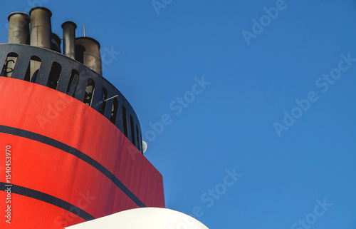 Red and black funnel of classic ocean liner cruise ship cruiseship Elizabeth Victoria against deep blue sky during cruise in summer	