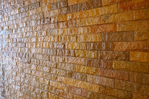 Brown bumpy stone brick wall for abstract background and texture for interior or exterior design. Beautiful patterns, space for work, banner, wallpaper close up.