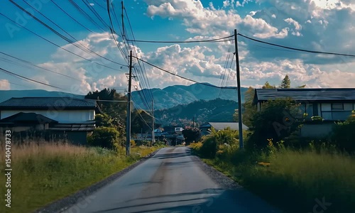 Sunny Day Rural Road View with Blue Sky White Clouds Green Grass and Asphalt Ground