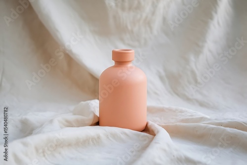 A bottle of white cosmetic cream on a towel, ready for a spa beauty treatment photo