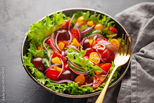 Easy vegetarian salad of fresh cucumber, tomato, sweet pepper, radish and onion . Healthy food.
