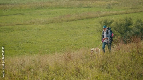 Therapeutic Hiking, Natural Rehabilitation. Senior Man With Backpack Treks Through Mountains With His Dog. A Calm, Healing Journey of Mobility Recovery and Outdoor Wellness After Retirement