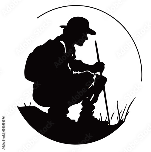 Silhouette of a male hiker in a hat, examining the ground in nature.