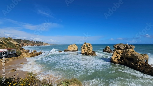Panoramic scenic view of the ocean, caves, large rocks under the blue sky in Albufeira Portugal
