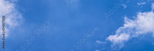 Clear blue sky with a few clouds. The sky is very bright and the clouds are scattered throughout